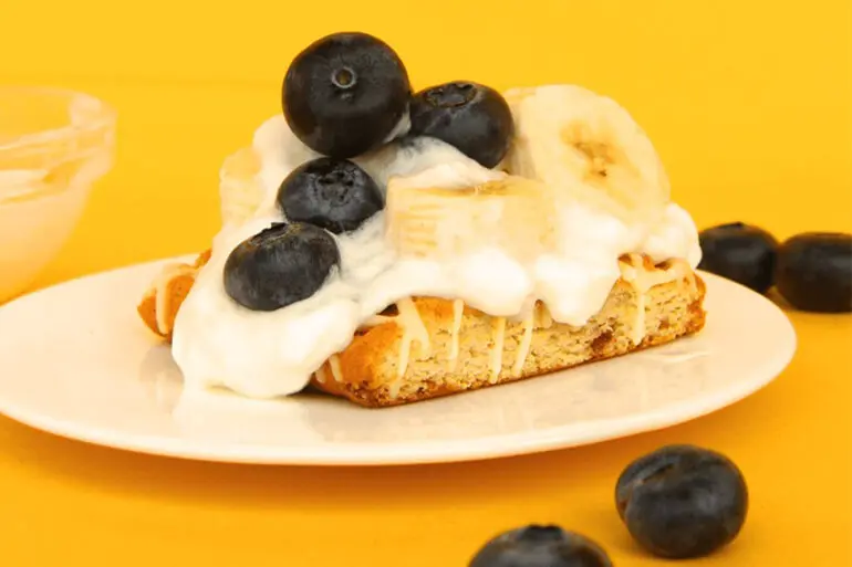 Fiber One Blueberry Banana Coffee Cake Recipe with ice creamea, bananas and blueberries on a white plate and yellow background