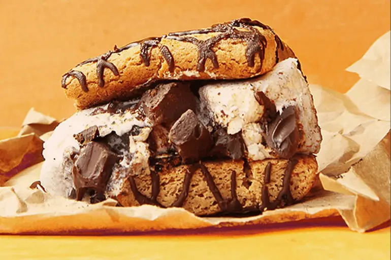 Fiber One chocolate chip smores bar recipe with ice cream and chocolate chips on a brown paper with a orange background